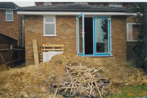 This shows the rear of the new extension with the completed pitch roof and french doors. The mound of waste was put to good use as we built a patio with steps down to the garden area.